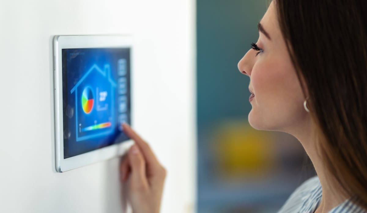 jolie-jeune-femme-utilisant-le-systeme-domotique-sur-tablette-numerique-pour-reguler-la-temperature